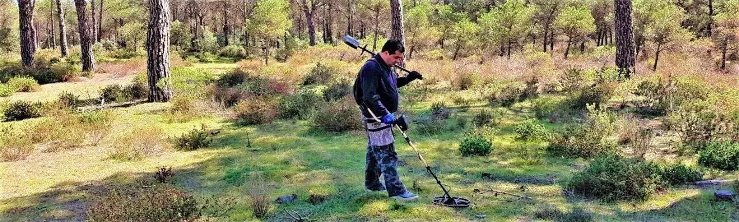 Prospecteur en sous-bois avec un détecteur de métaux